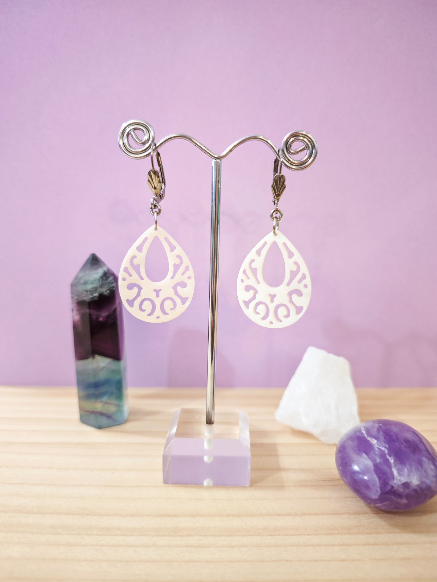 Boucles d’oreilles en nacre blanche ajourée en forme de goutte montées sur dormeuses en acier inoxydable, création artisanale Julie Gassmann.