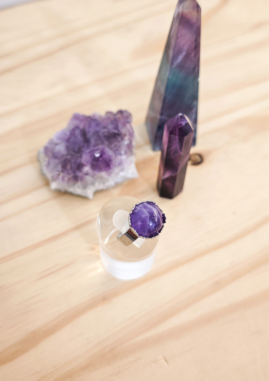 Bague artisanale en améthyste violette montée sur une base ajustable en acier inoxydable, création faite main et pièce unique.