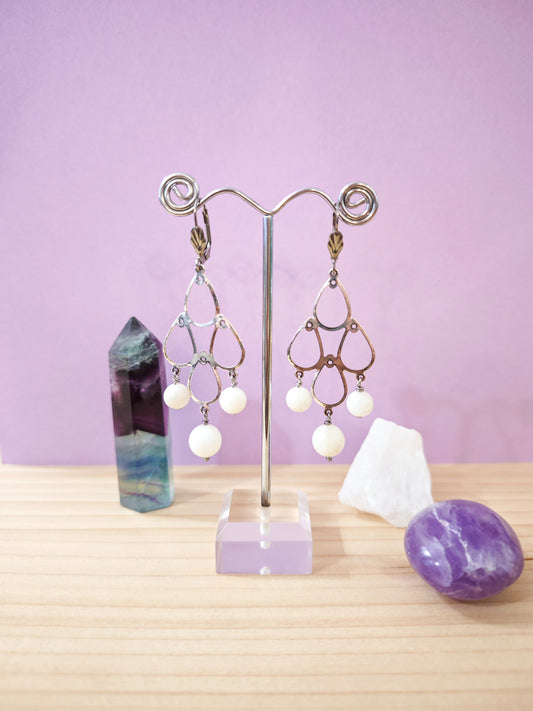 Boucles d’oreilles chandelier en nacre blanche avec motif ajouré et dormeuses en acier inoxydable, création artisanale Julie Gassmann.