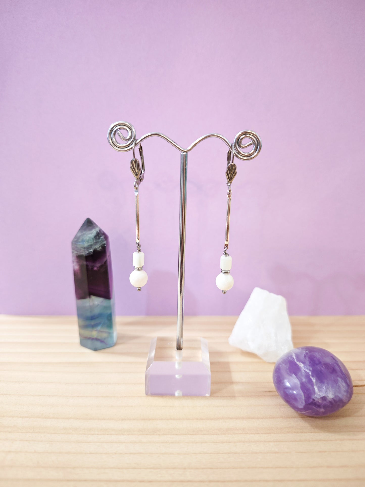 Boucles d’oreilles minimalistes en nacre blanche avec perles suspendues sur dormeuses en acier inoxydable, création artisanale Julie Gassmann.