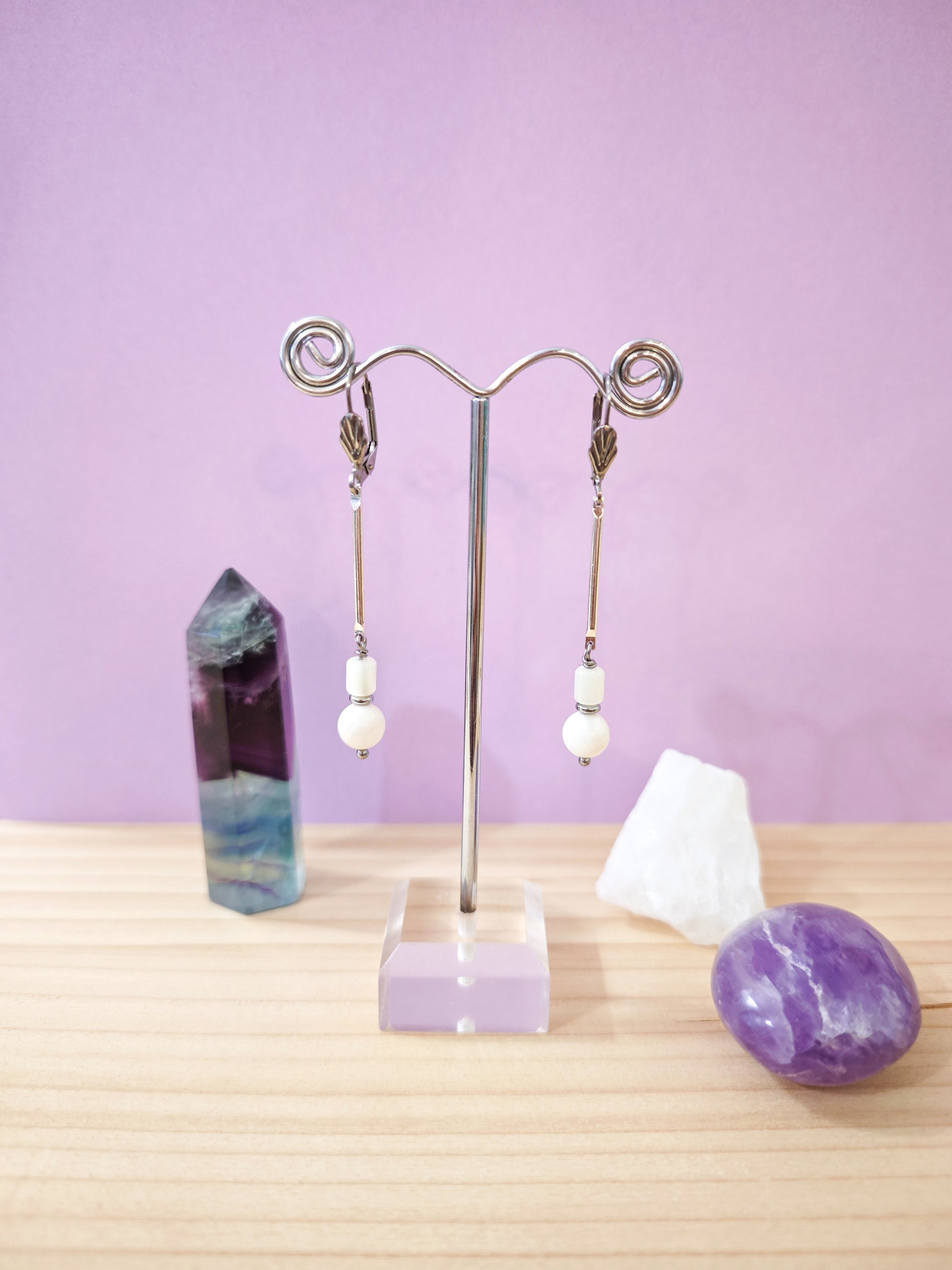Boucles d’oreilles minimalistes en nacre blanche avec perles suspendues sur dormeuses en acier inoxydable, création artisanale Julie Gassmann.
