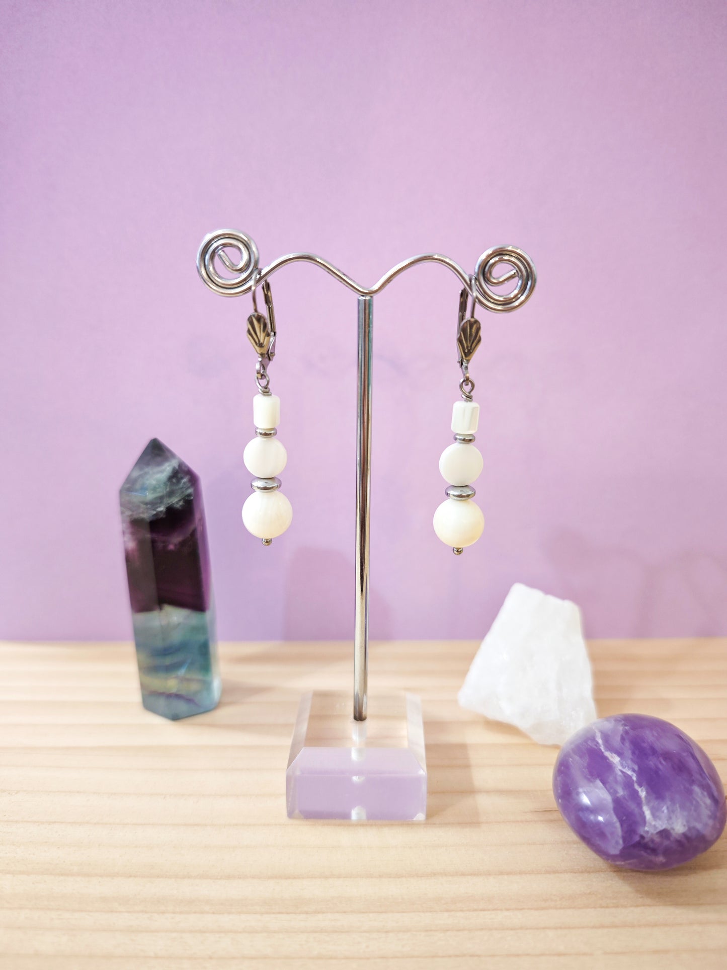 Boucles d’oreilles pendantes avec perles de nacre blanche montées sur dormeuses en acier inoxydable, création artisanale Julie Gassmann.