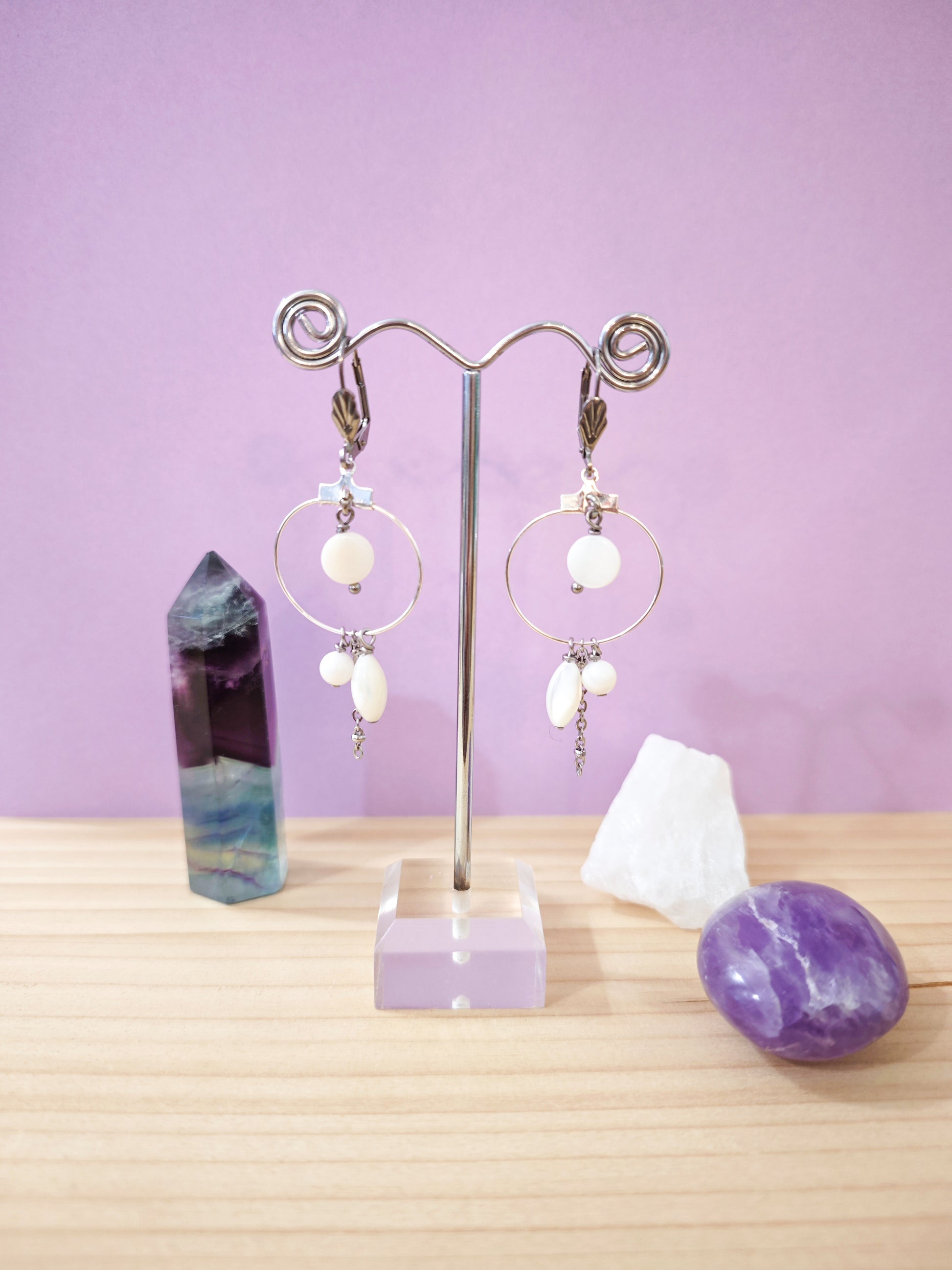 Boucles d’oreilles créoles avec perles de nacre blanche suspendues montées sur dormeuses en acier inoxydable, création artisanale Julie Gassmann.
