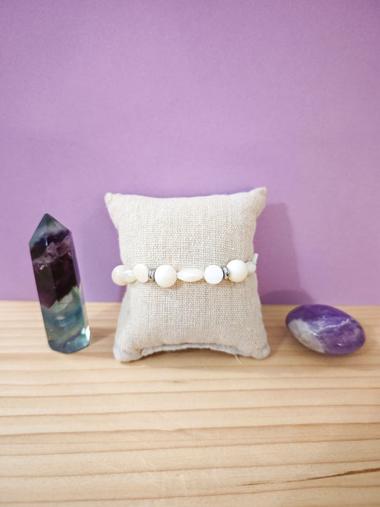 Bracelet artisanal en nacre blanche naturelle et acier inoxydable posé sur présentoir, création Julie Gassmann Bijoux faite à Nogent-sur-Marne.